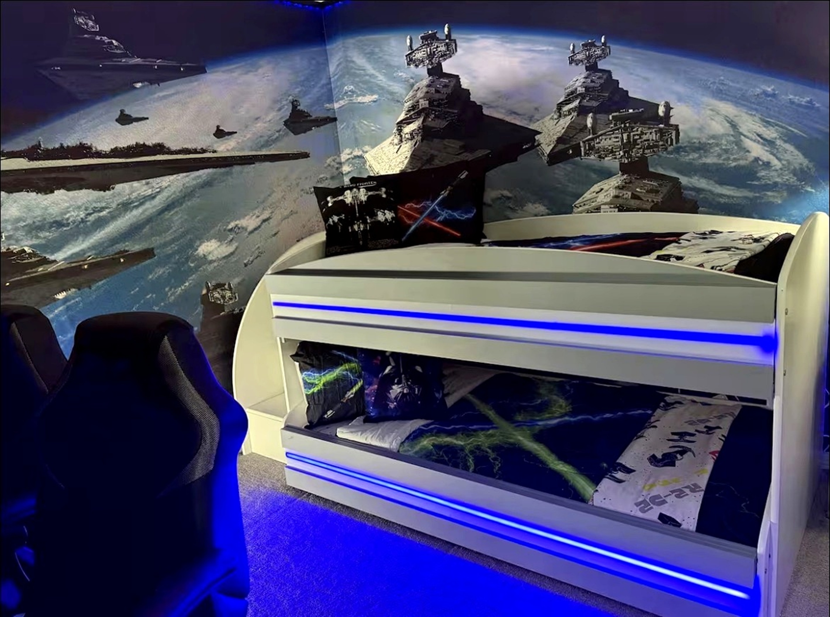 A space-themed bedroom featuring a bunk bed with blue LED lighting and a galactic wall mural.