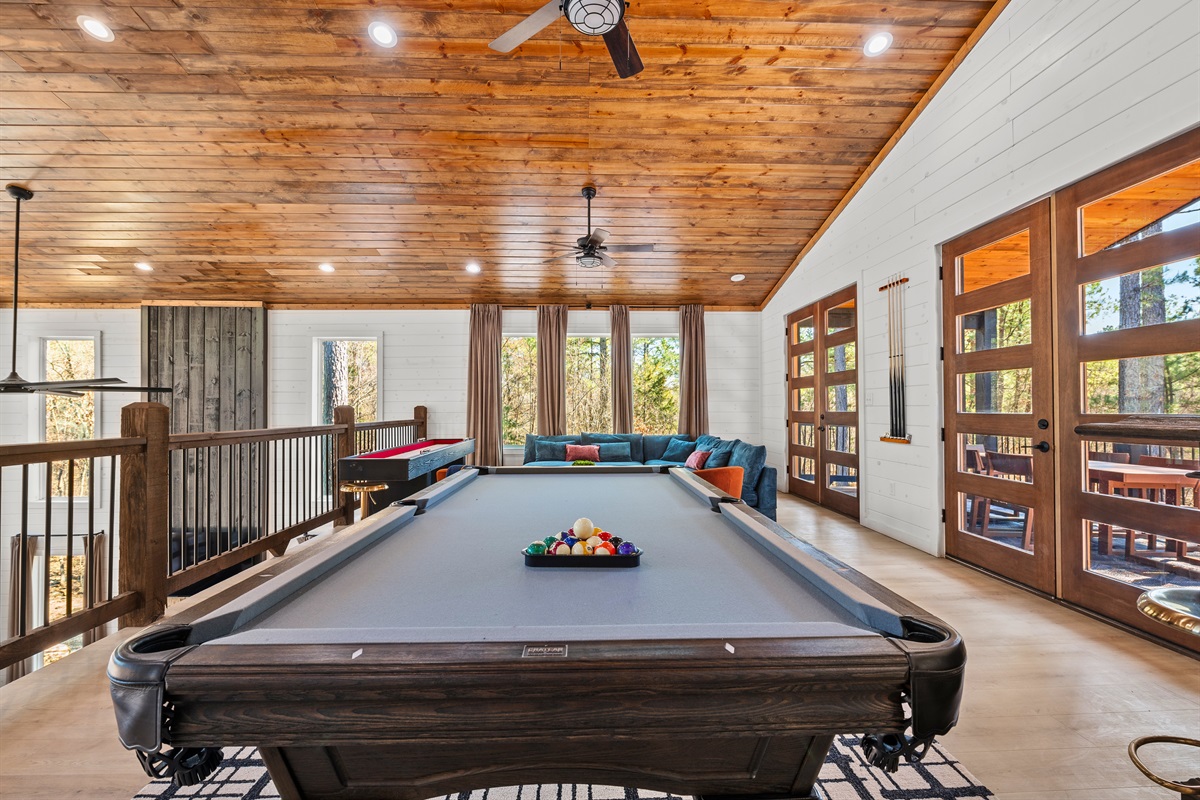 The upstairs loft area offers more space to unwind, with a pool table and comfortable seating for casual hangouts.