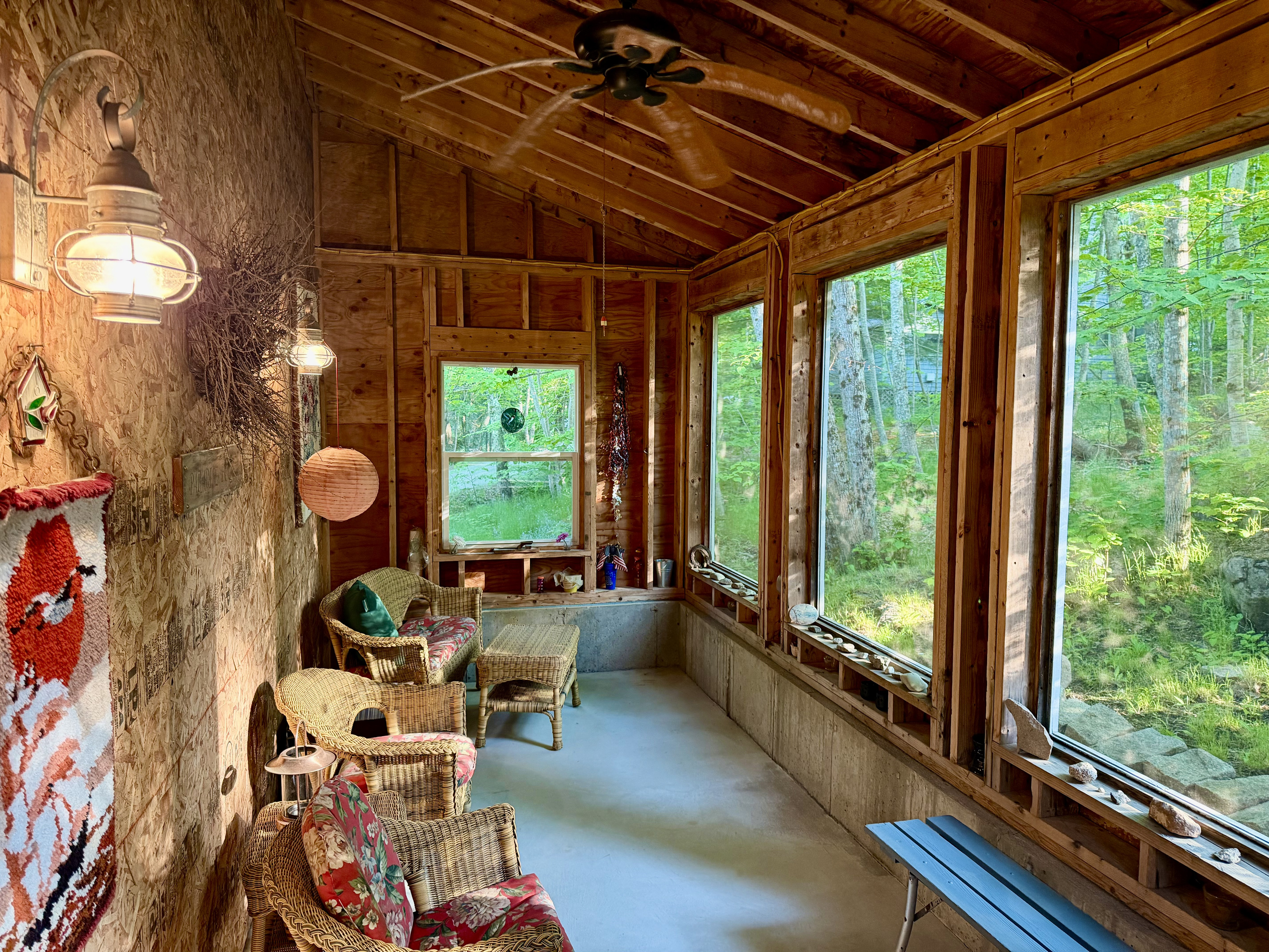 Look at all this extra room to stretch out. The Settler’s Sidecar interior boasts comfortable wicker seating, an overhead fan, and floor-to-ceiling screens framing lush woodland views. A peaceful, bug-free sanctuary on the property.