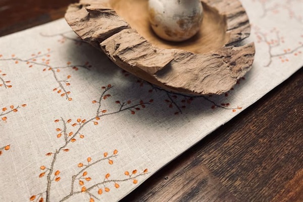A sculptural bird rests atop a wooden burl, a naturally twisted growth in the wood, adding organic beauty and character to the table.