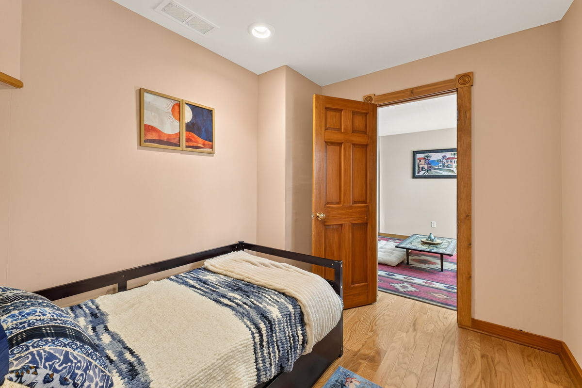 Bedroom with patterned bedding and doorway