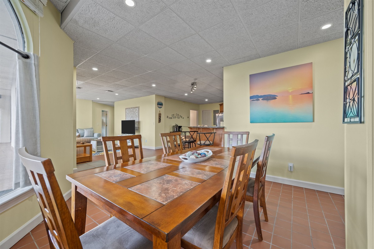 Spacious dining area framed by arched windows with open sightlines to the kitchen and living space