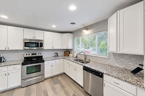 Kitchen: Bright and sleek space with granite counters, modern appliances, and plenty of natural light!