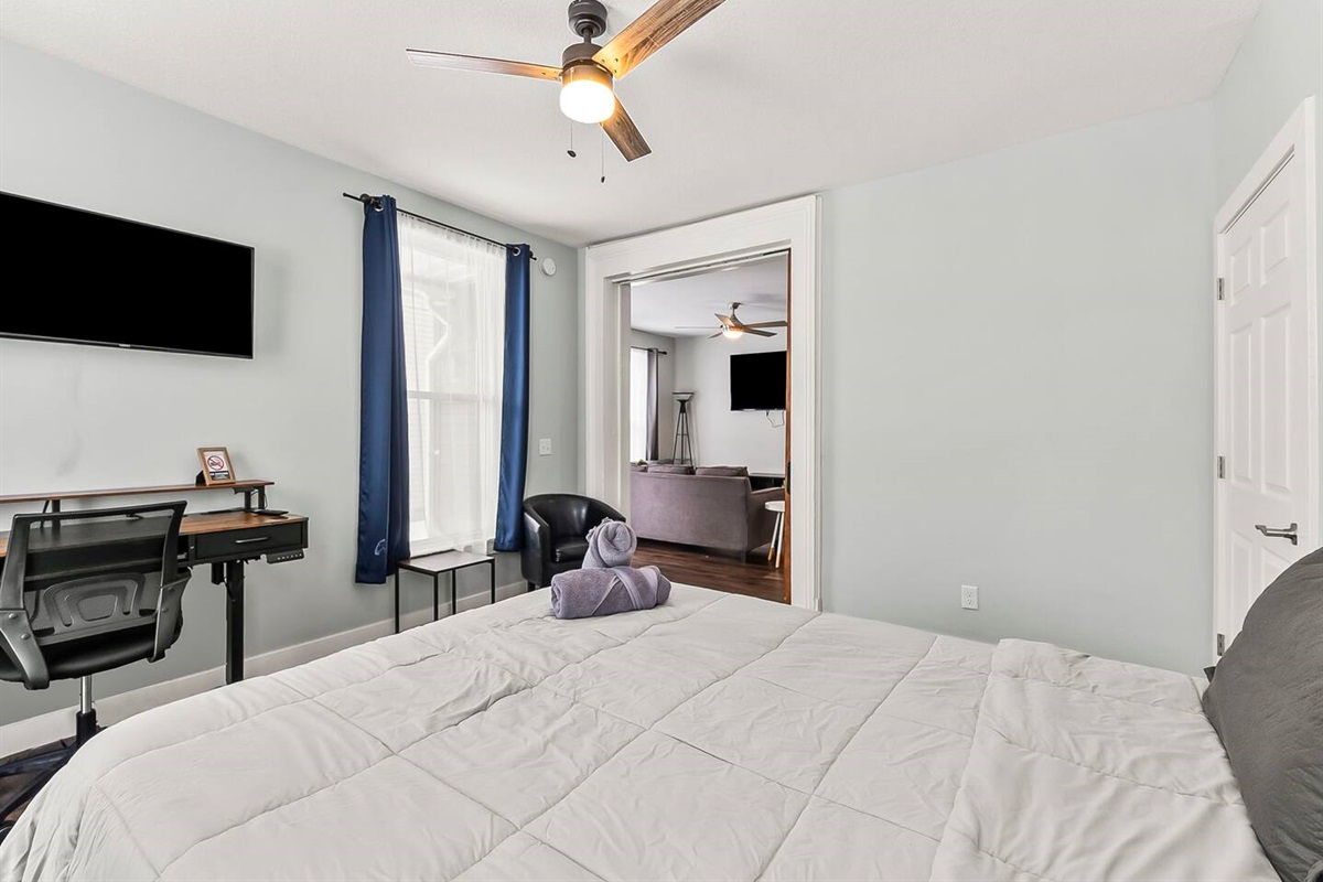 Bedroom workspace setup with desk, chair, wall-mounted TV, and peaceful views—ideal for remote work.