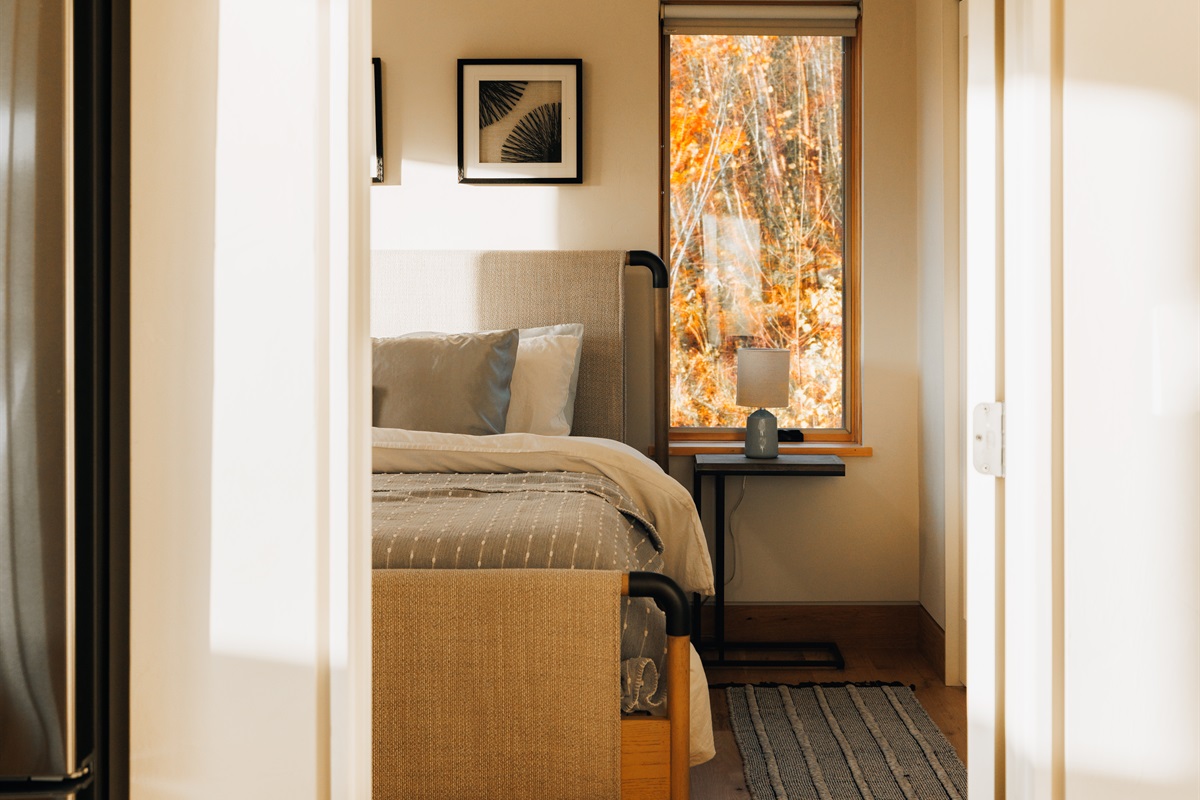 Upstairs king bedroom tucked behind the doorframe with built-in desk and TV.