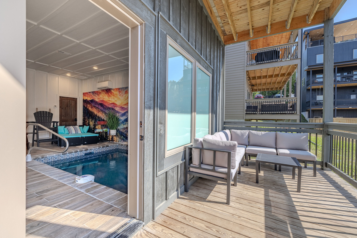 Step directly from the indoor pool area onto the covered deck that holds the hot tub and a comfy sectional.