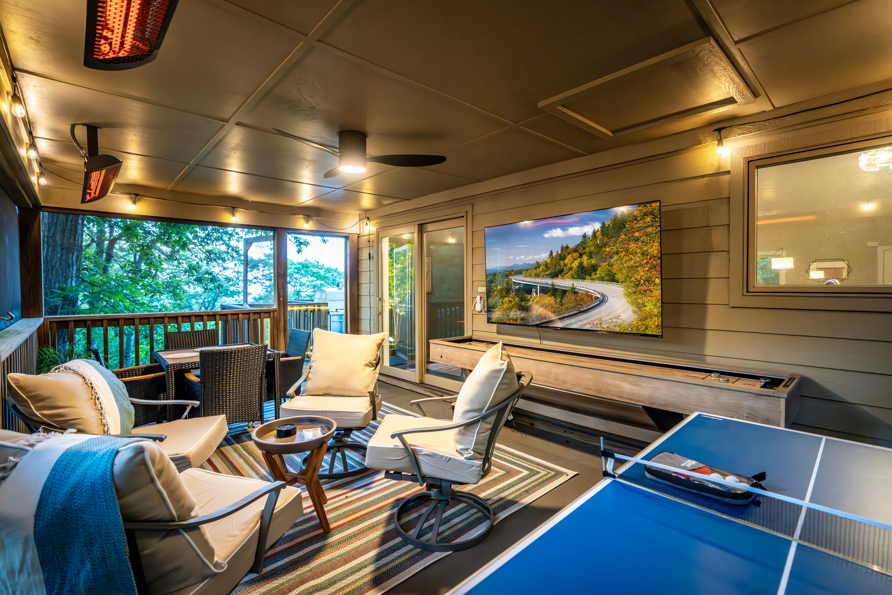 All-weather, screened game porch with 75” TV, ping pong, shuffleboard, and radiant heaters — a stylish space for play, connection, and unwinding