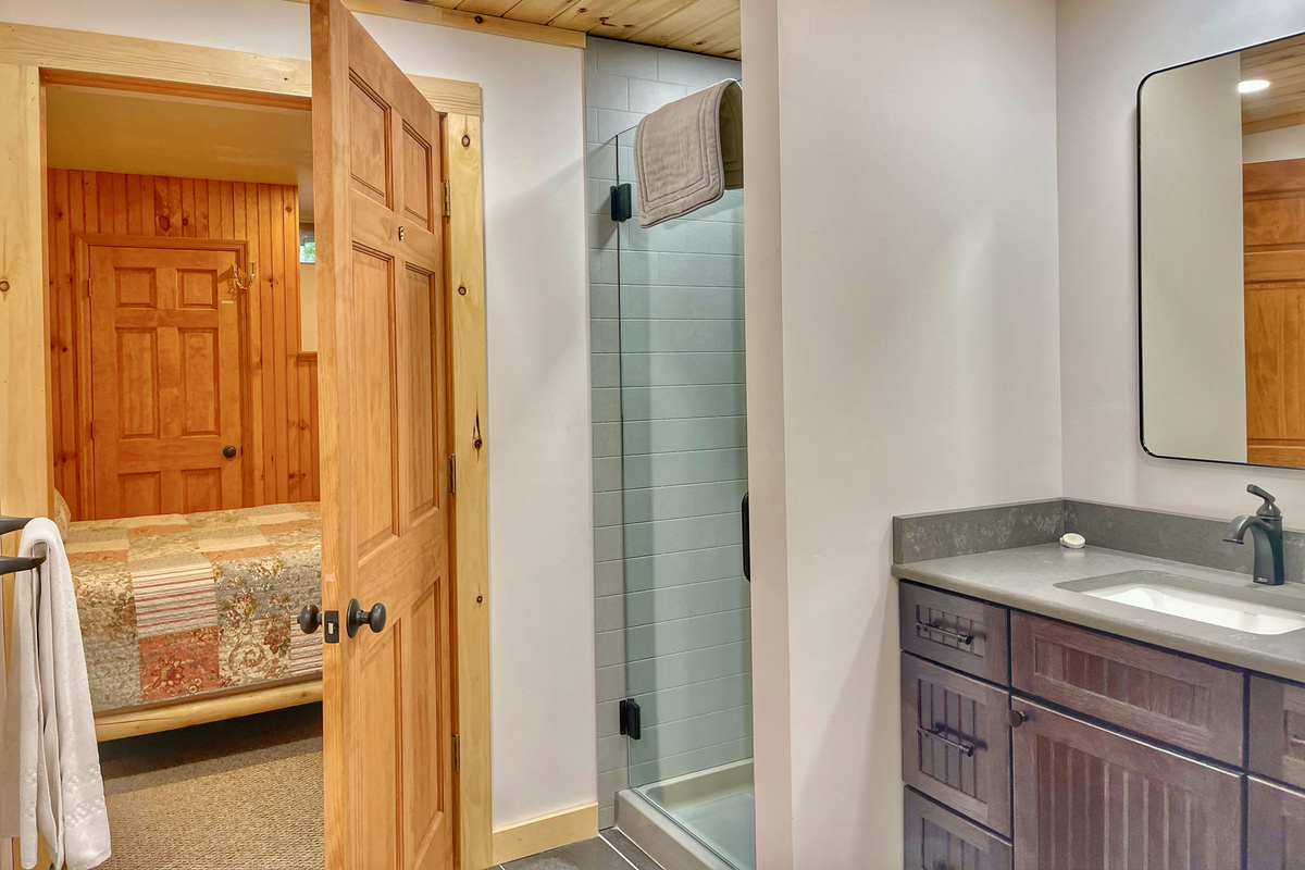The spacious ensuite bathroom with a step-in shower is conveniently located just off the lower-level bedroom. This bathroom offers step-free access from the bedroom. 