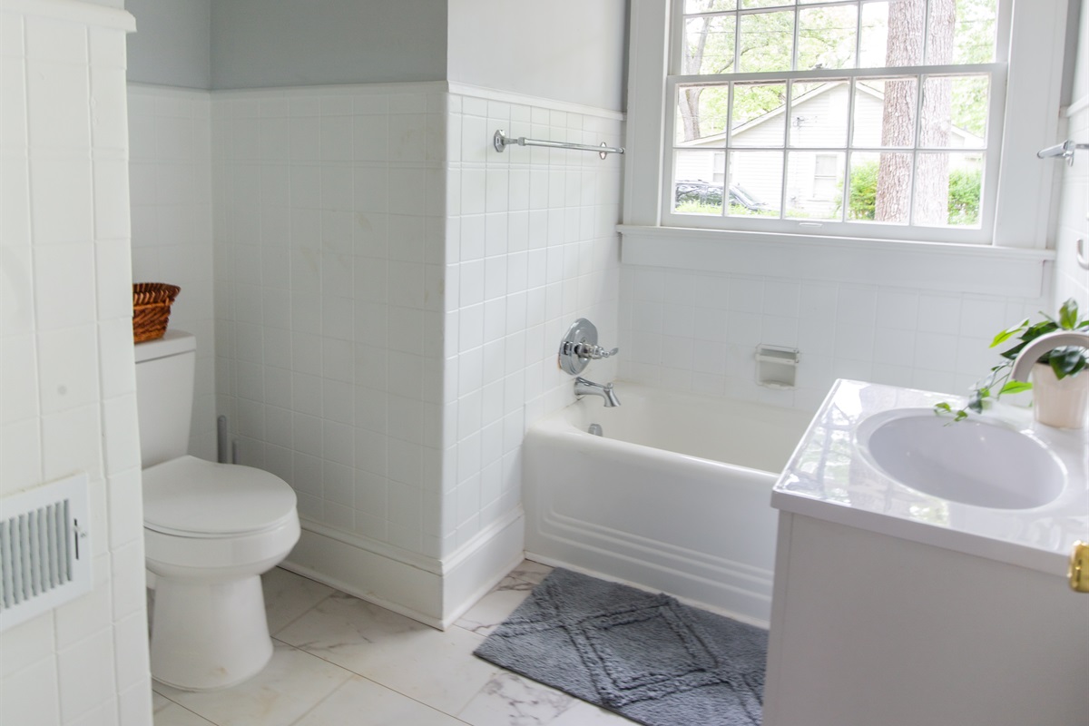 The hall bathroom features a tub and shower combination (privacy film has been added to the windows)