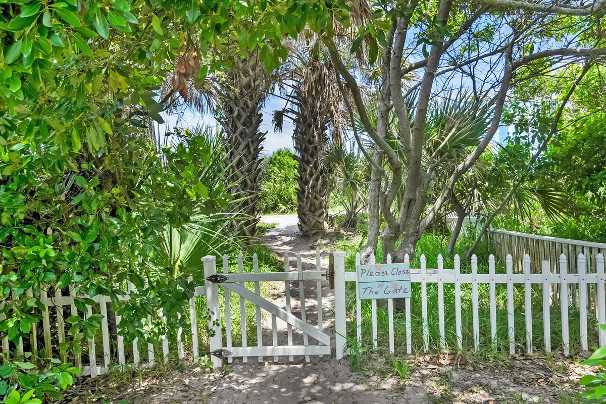 Through the gate the path opens up between the palms and the sea grape towards the sand. Three minutes from the front door, and it is the walk that will end up defining the rhythm of your entire week.