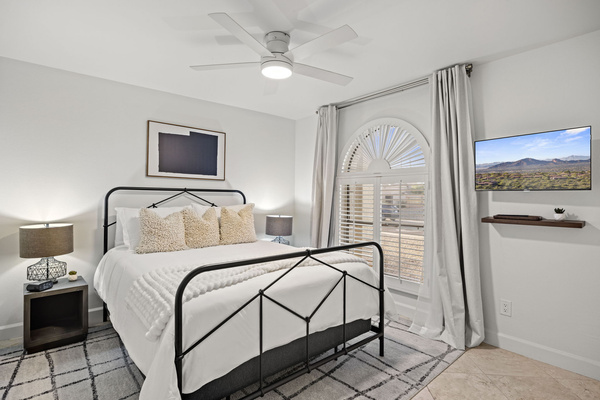 Guest bedroom with closet storage, full length mirror, flat screen TV and comfortable sleeping setup