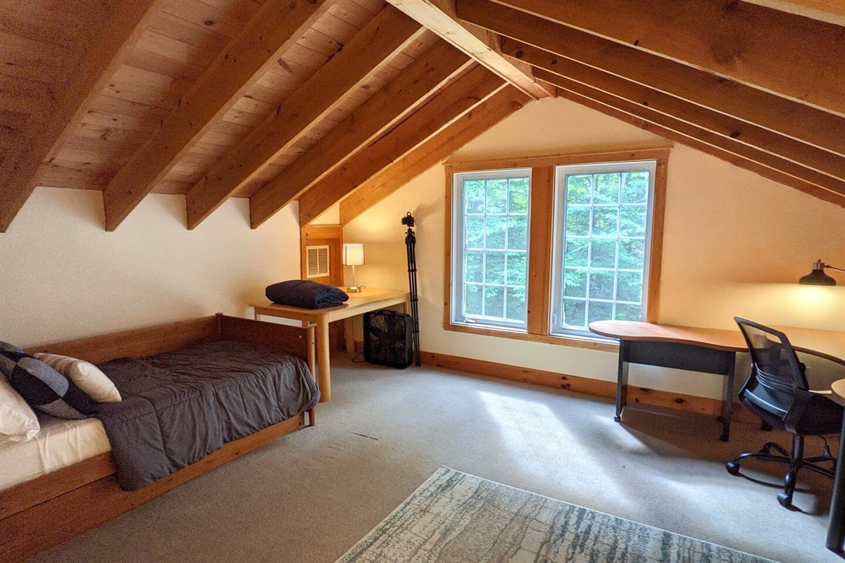 Loft with twin trundle bed dedicated work space, and TV. Please note there is a privacy screen separating the loft from the stairs leading down to the main level.