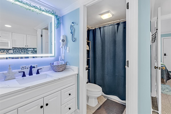 Full bathroom with walk-in shower, LED mirror, and dual sink vanity