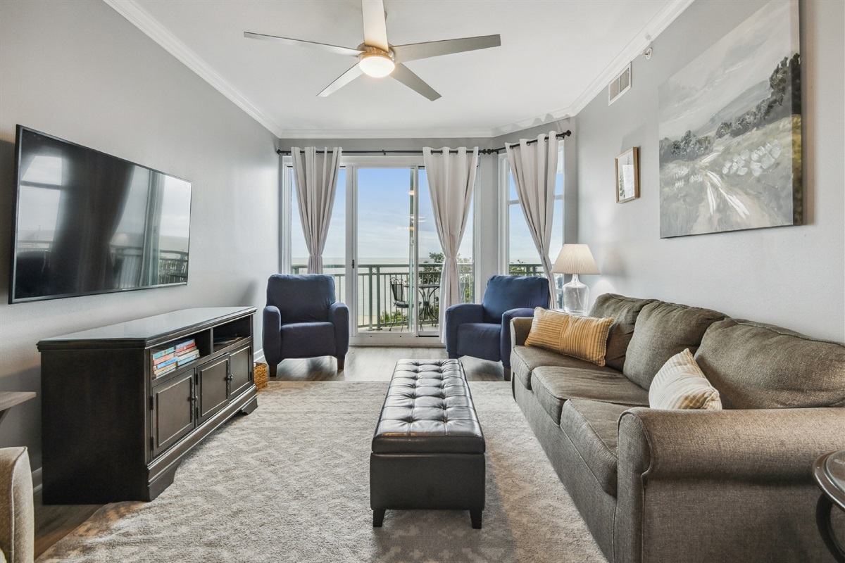 Living room looking out balcony window. Queen sleeper sofa.