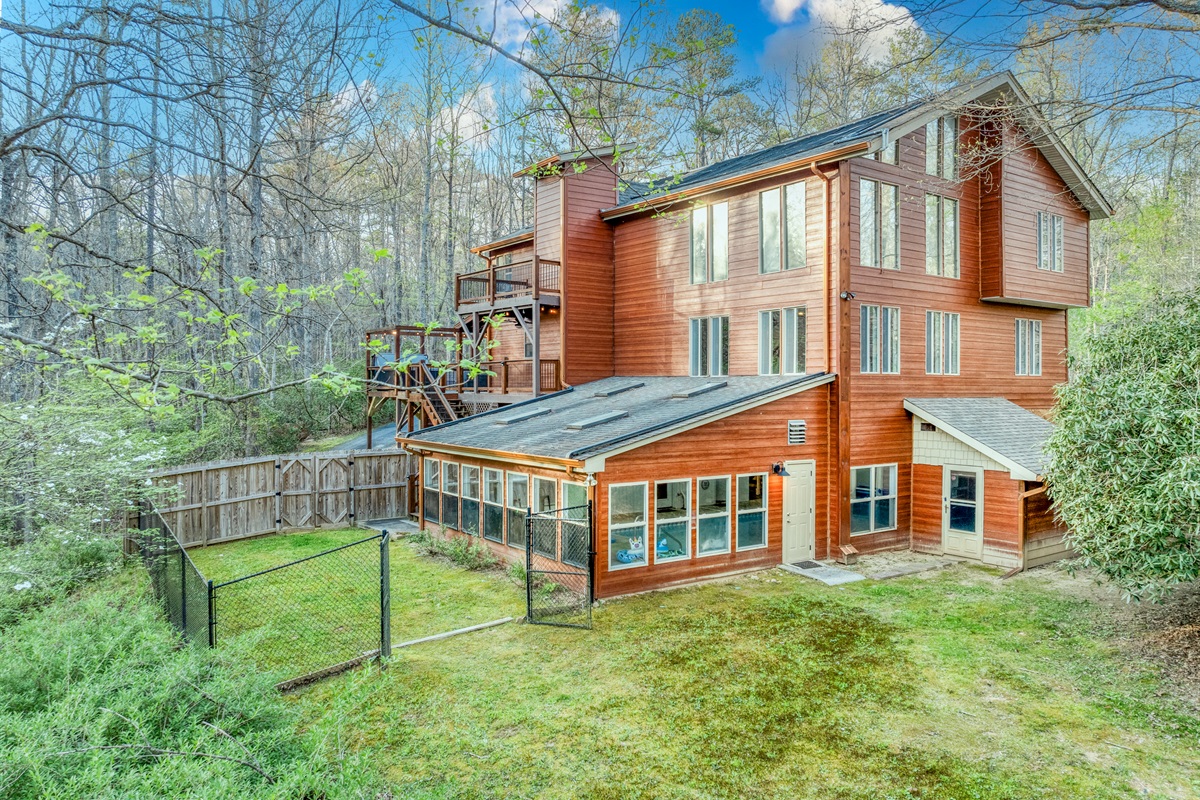 Back view of house showing indoor pool and fenced in back yard