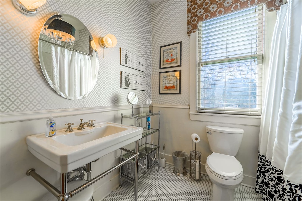 Bright bathroom with decorative tiles, an oversized sink, and embellishing touches. 