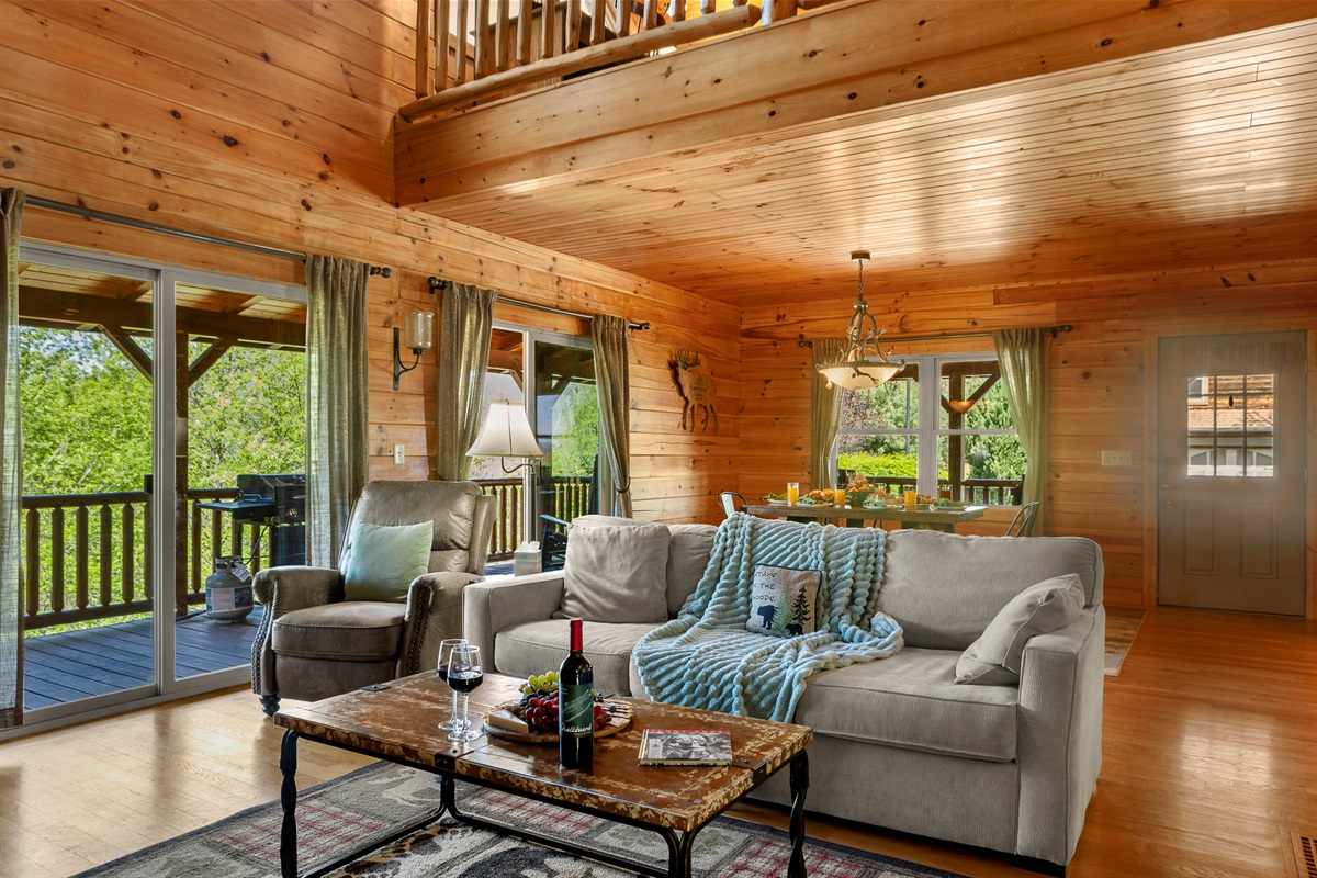 Living Room Retreat: Bright wooden accents, plush furnishings, and scenic views await your relaxation!