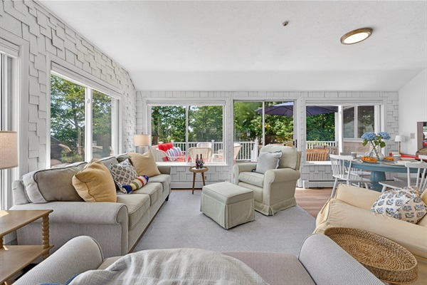Stylish living room filled with soft daylight, offering a spacious and comfy setup ideal for both relaxation and casual entertainment.