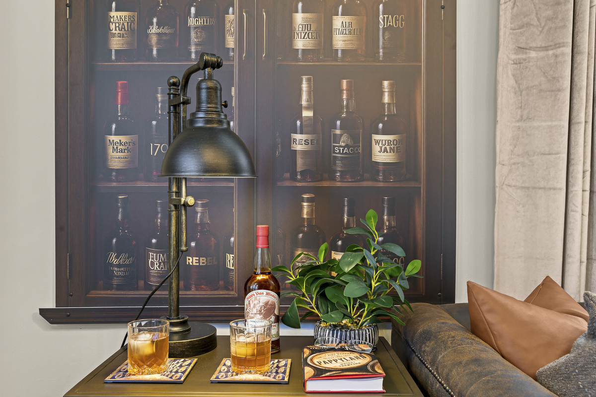 With two rocks glasses, a pour of Bulleit, and a brass side table nearby, the living room is perfectly set for happy hour.