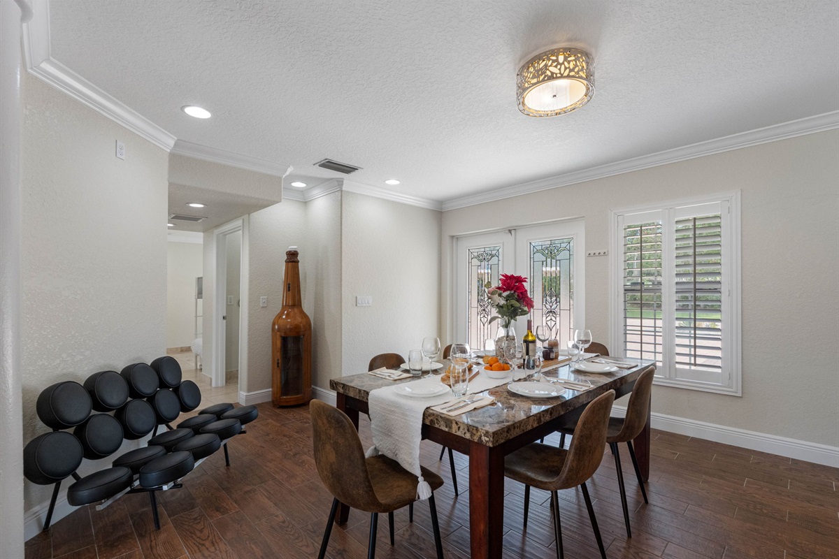 Set with a stone-look table, comfortable suede-style chairs, and tasteful place settings, this dining area is ready for memorable meals.