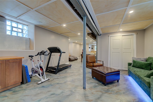 Rec room, with exercise equipment, arcade, 85" tv and a queen sofa bed