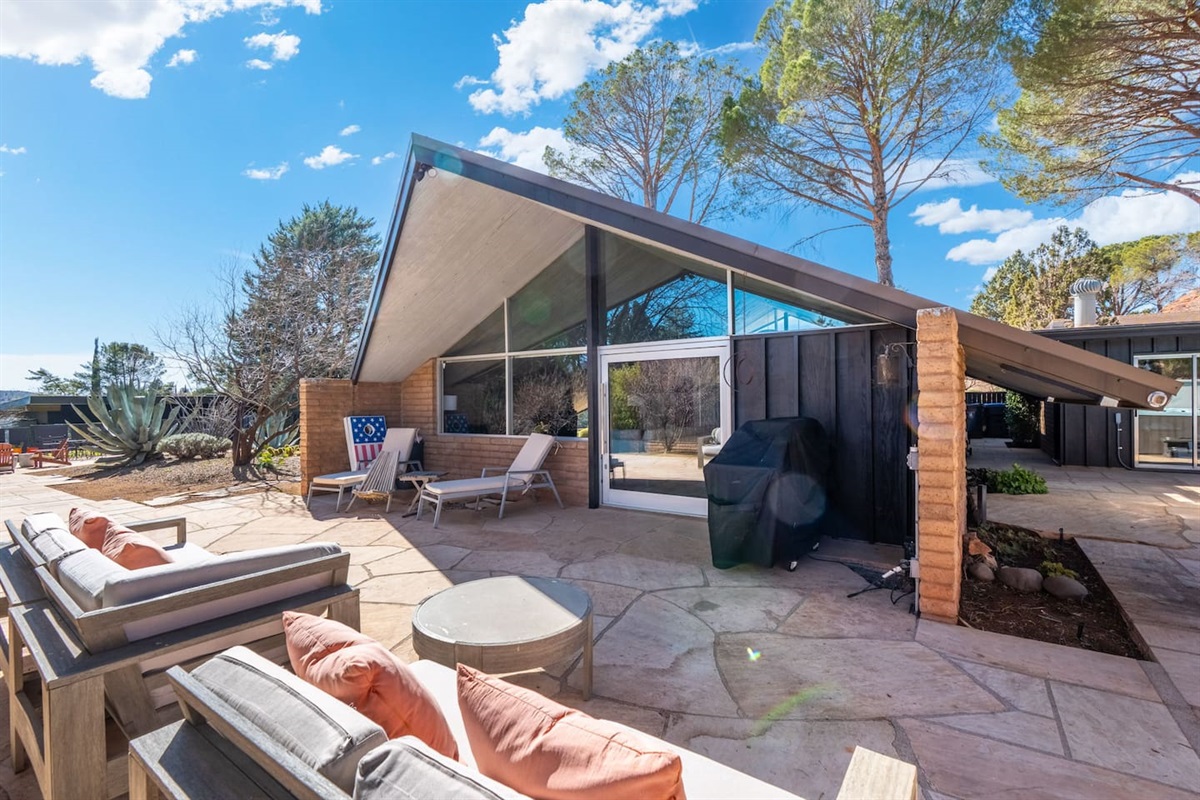 Stylish mid-century exterior with iconic sloped rooflines, expansive windows, and a spacious private patio — perfect for lounging, grilling, and soaking up the Arizona sunshine.