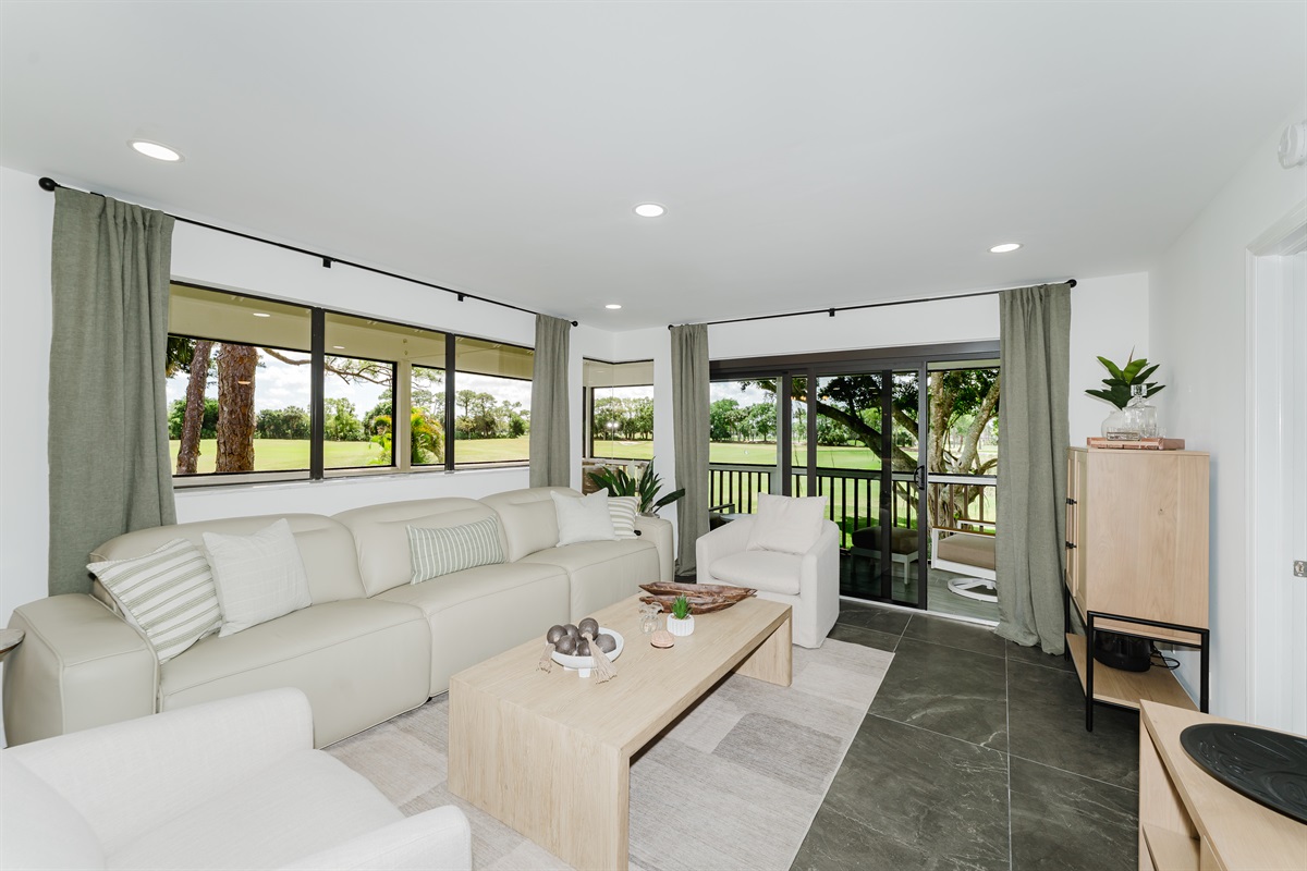 Bright, open living space filled with natural light and golf course views. Comfortable seating is perfect for relaxing after a day at the beach or golf. A spacious living area designed for both comfort and style.