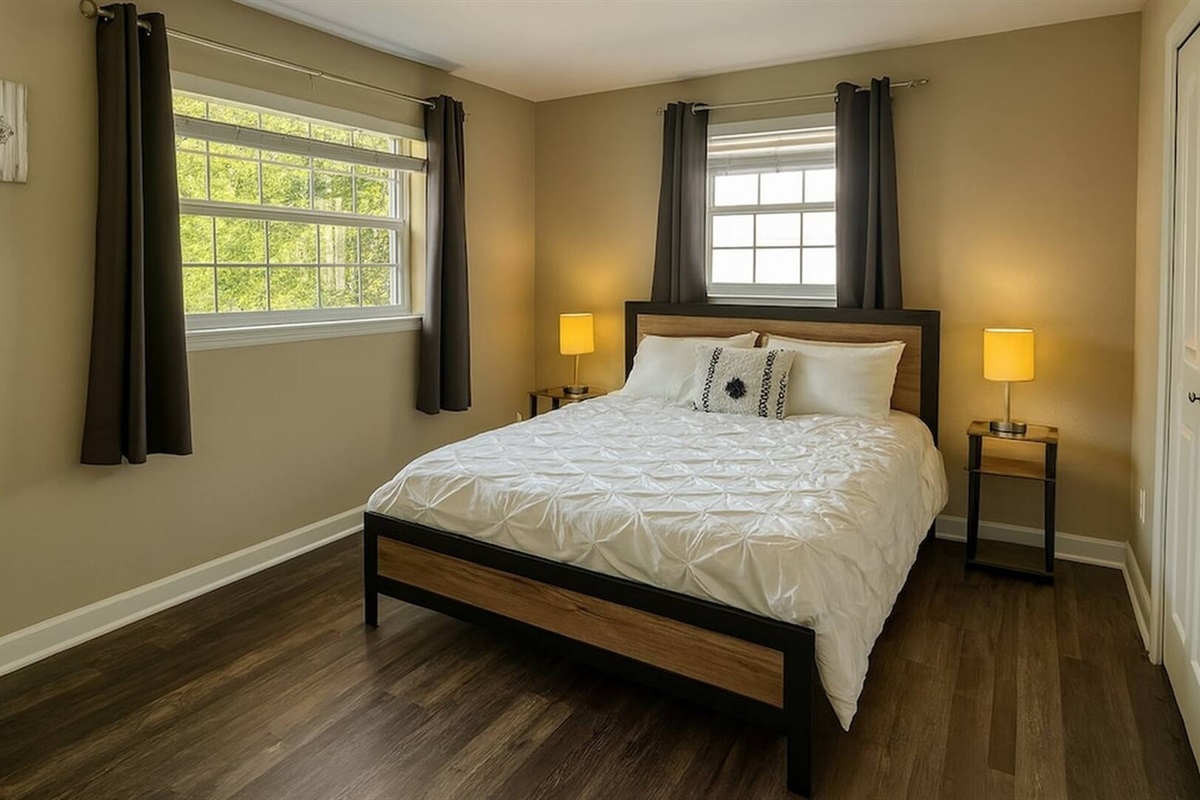 Bedroom 3 - Spacious bedroom with queen bed, dual windows, and ample natural lighting