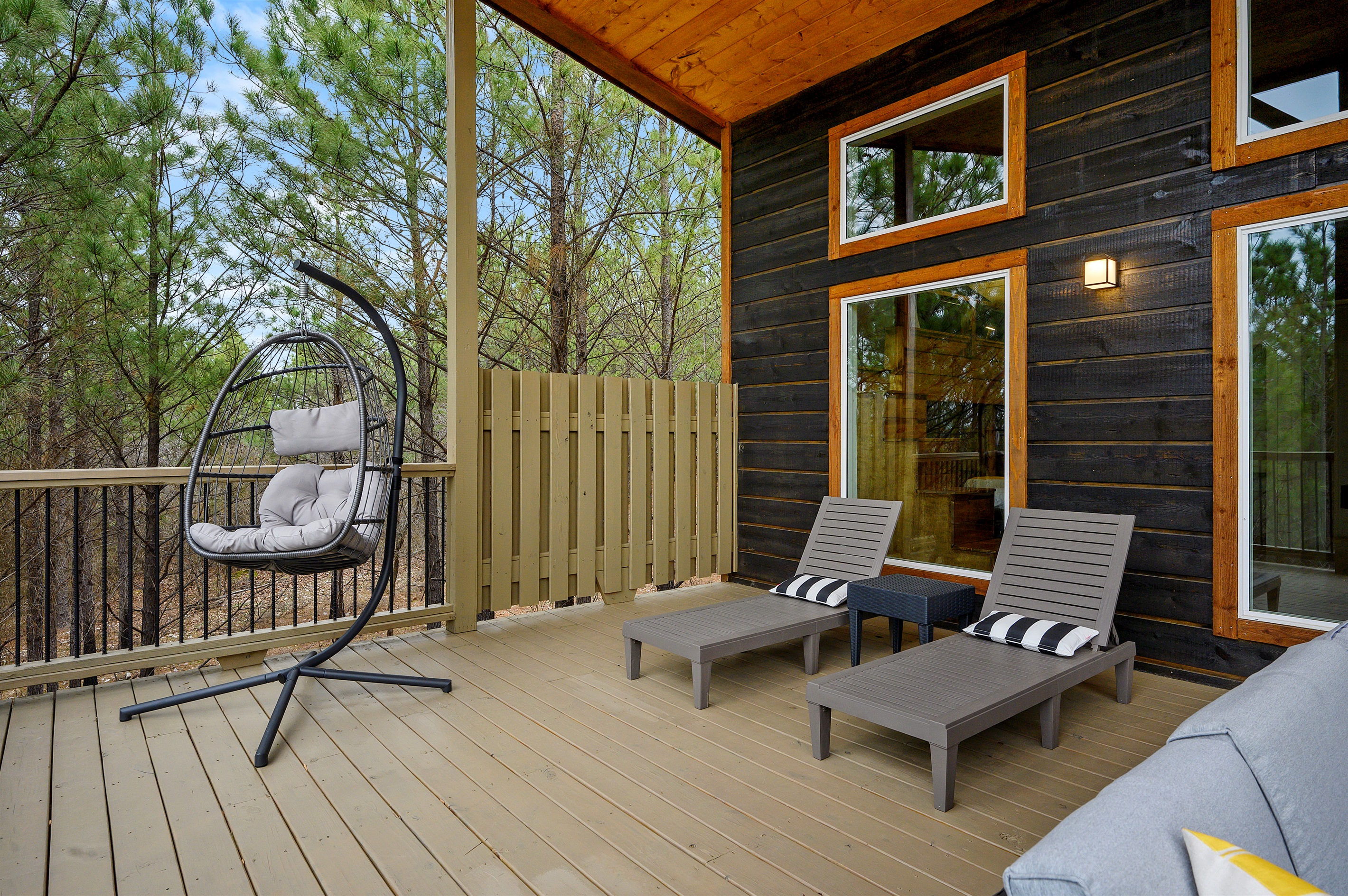 A cozy outdoor relaxation space featuring sun beds and a hanging chair — ideal for lounging, swaying gently, and enjoying peaceful moments surrounded by nature.
