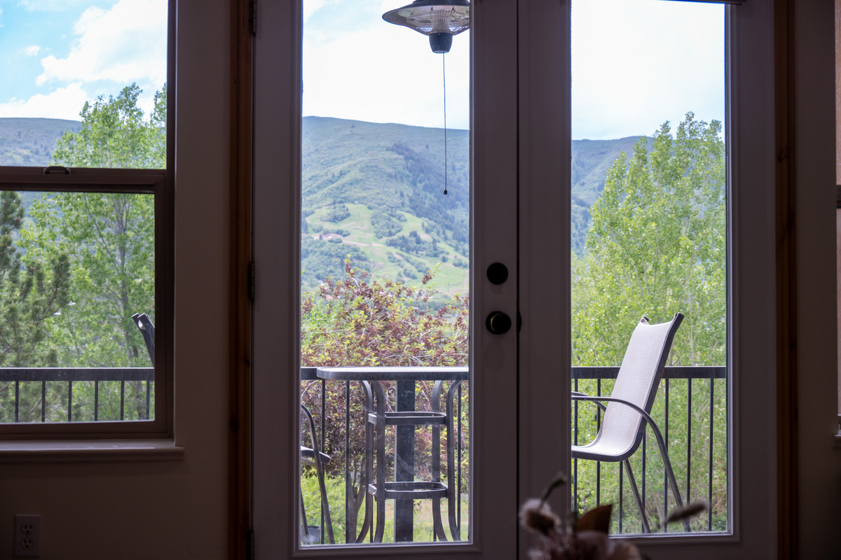 A large patio and a wall of windows frame breathtaking mountain views, bringing the beauty of Ogden Valley right into the living space.