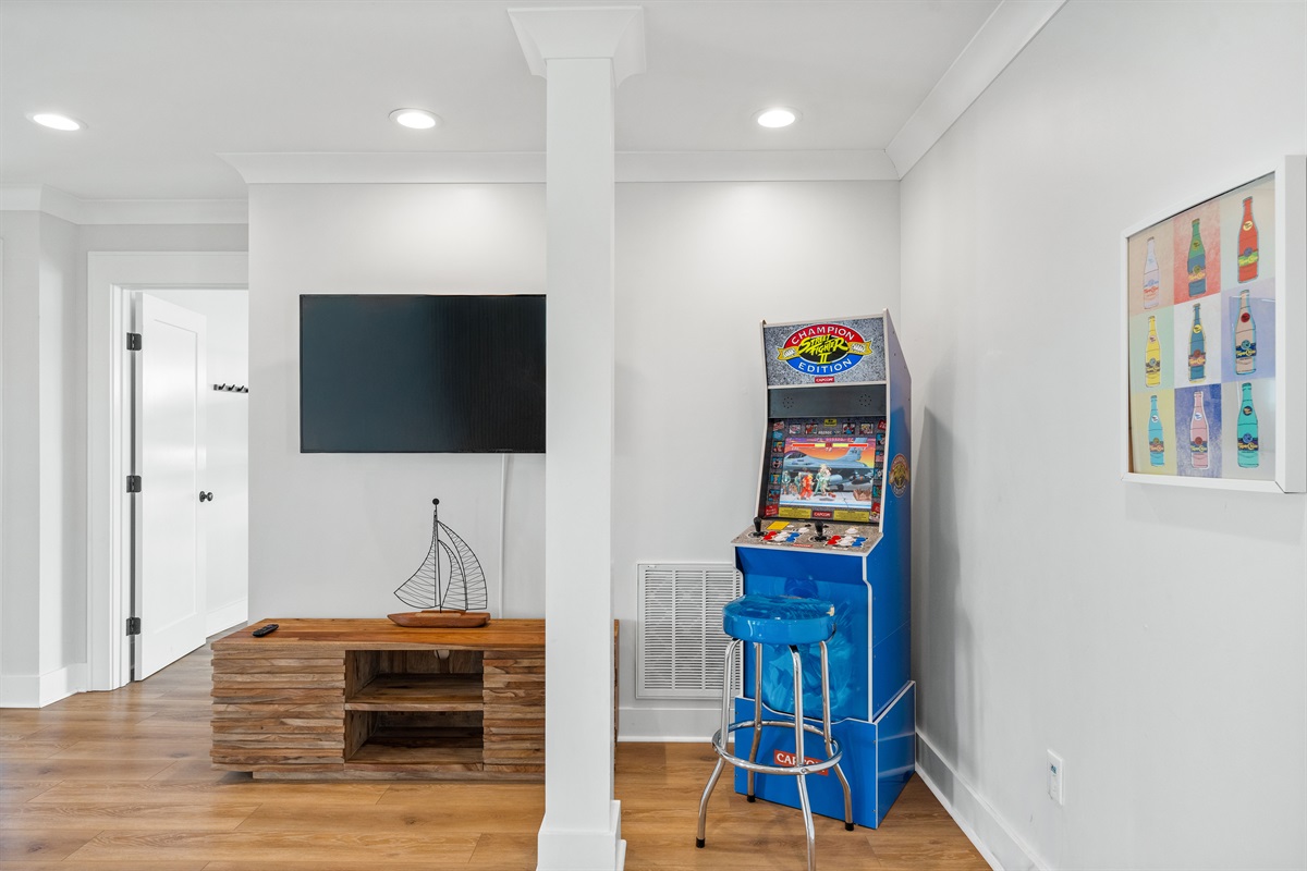 Fun-filled 2nd-floor game room featuring arcade entertainment, lounge seating, and TV for movie nights