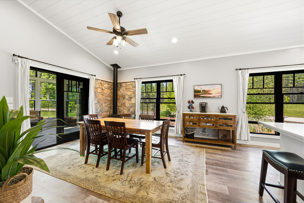 Enjoy family dinners at the solid-wood dining table, warmed by a cozy propane fireplace set against a dramatic floor-to-ceiling stone wall.