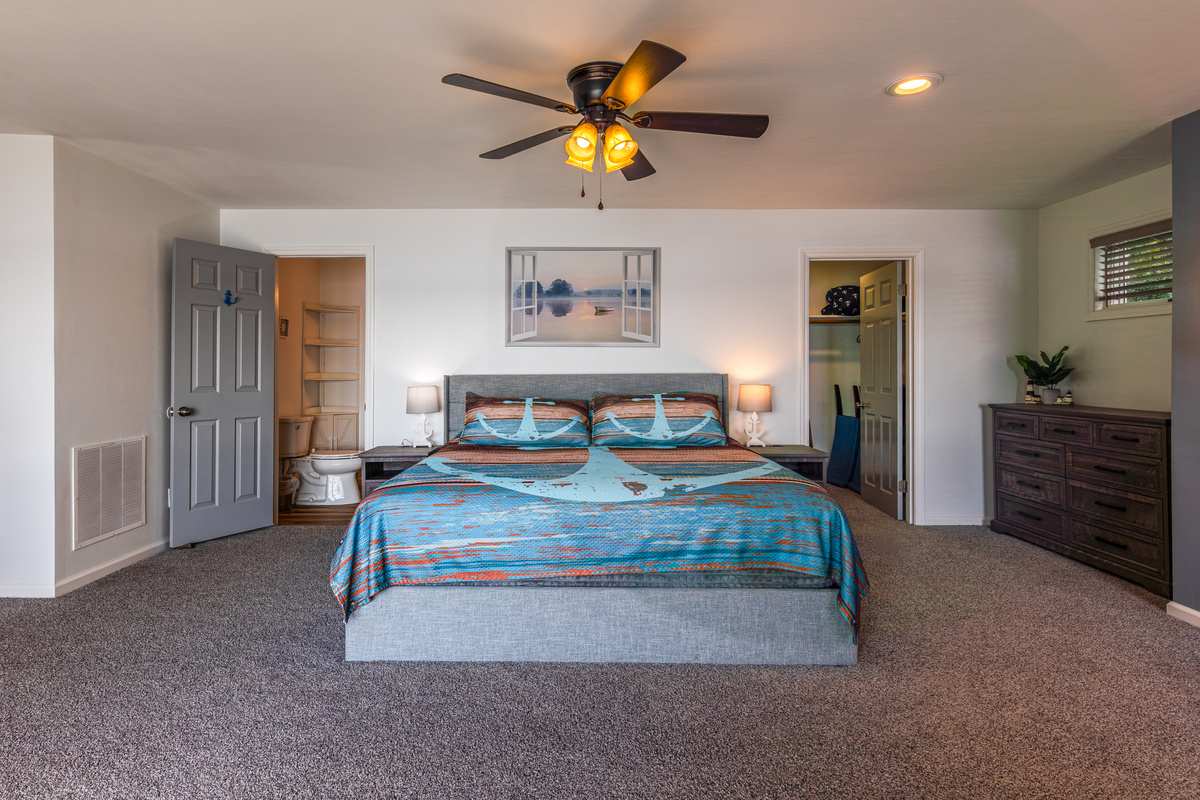 The primary suite features a king bed, bedside lighting, dresser storage, and room to settle in comfortably.