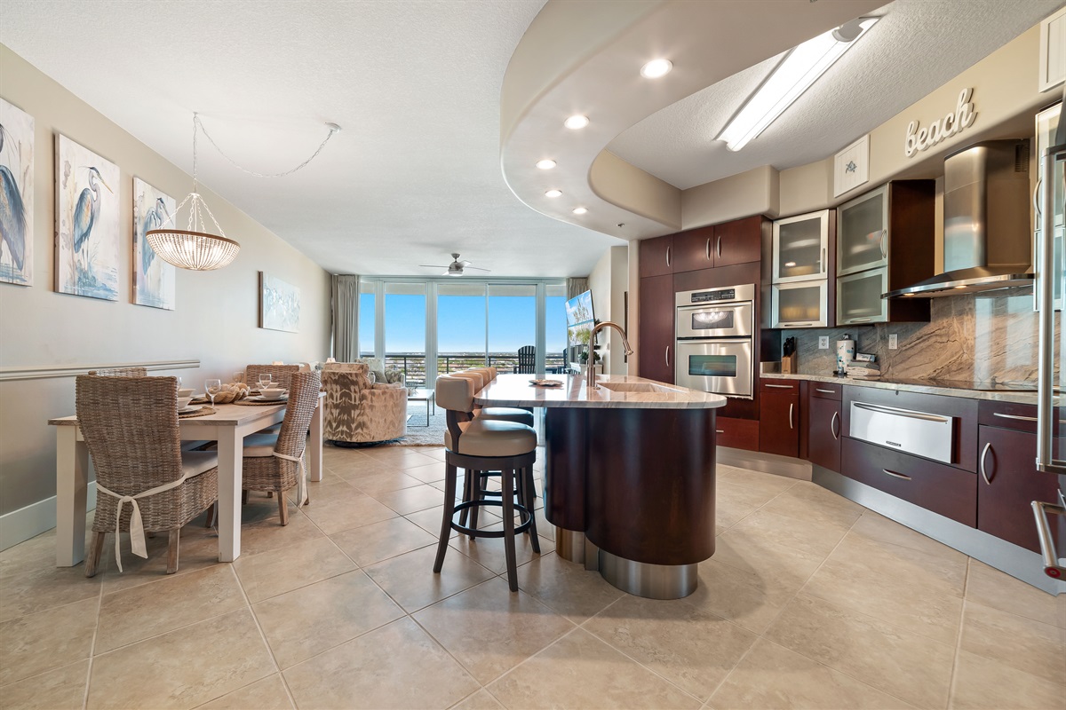This gourmet kitchen, featuring stainless steel appliances and granite countertops, seamlessly flows into the spacious living area, perfect for entertaining and enjoying breathtaking views.