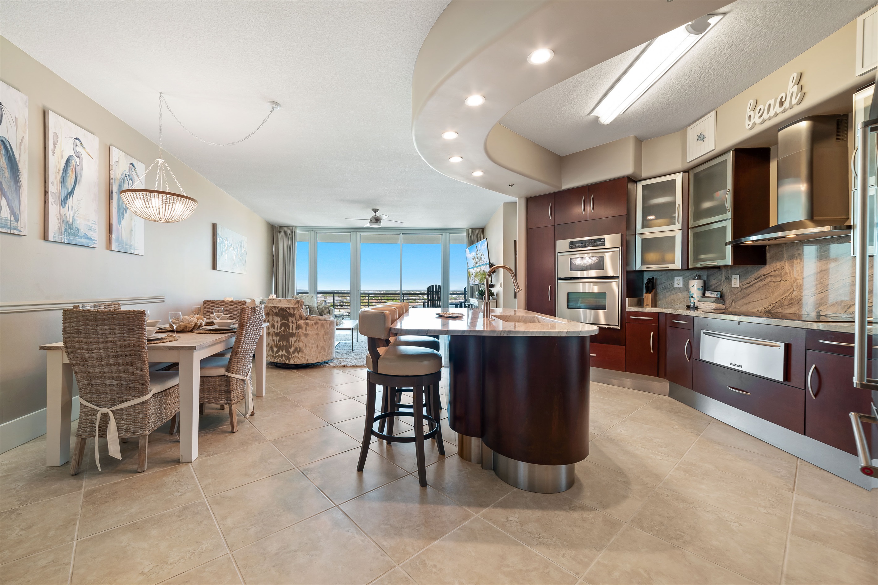 This gourmet kitchen, featuring stainless steel appliances and granite countertops, seamlessly flows into the spacious living area, perfect for entertaining and enjoying breathtaking views.
