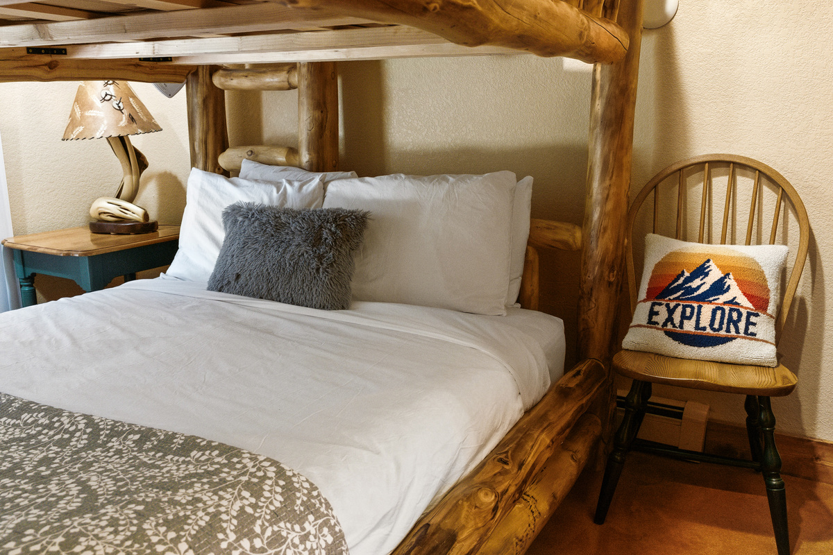Lower level guest bedroom #3 with Queen-over-Queen bunk, sliding door for patio access, tv and attached bathroom with shower. 