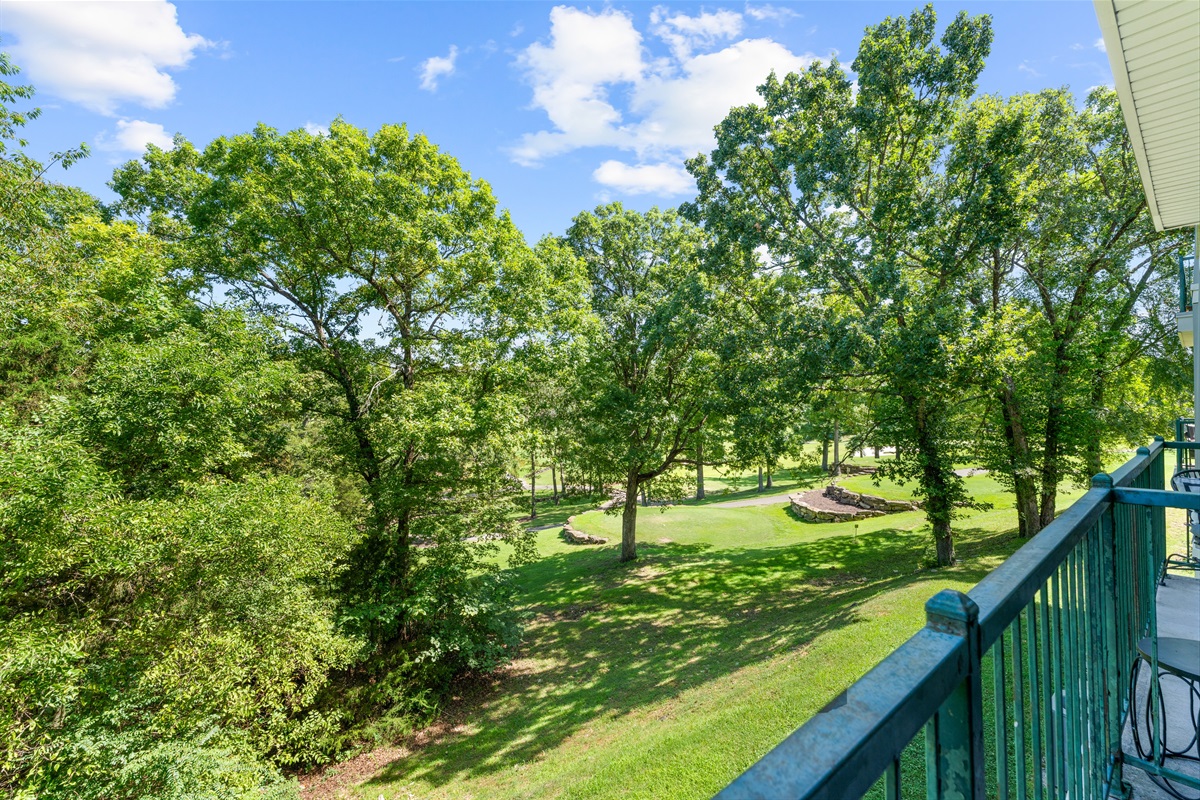 Peaceful deck view across trees and greens brings a little breathing room to your stay.