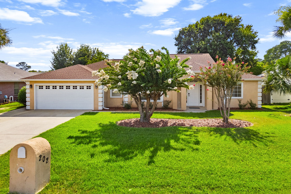 Welcome to Treasure Palms Villa! Our well-maintained single-story vacation home with a manicured green lawn, two blooming pink and white crepe myrtle trees in the front yard, a concrete driveway leading to your private entry. 