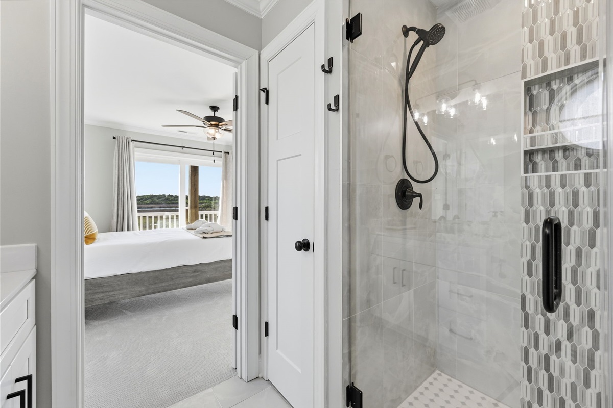 Spa-style walk-in shower with elegant tilework and premium fixtures for a refreshing stay

