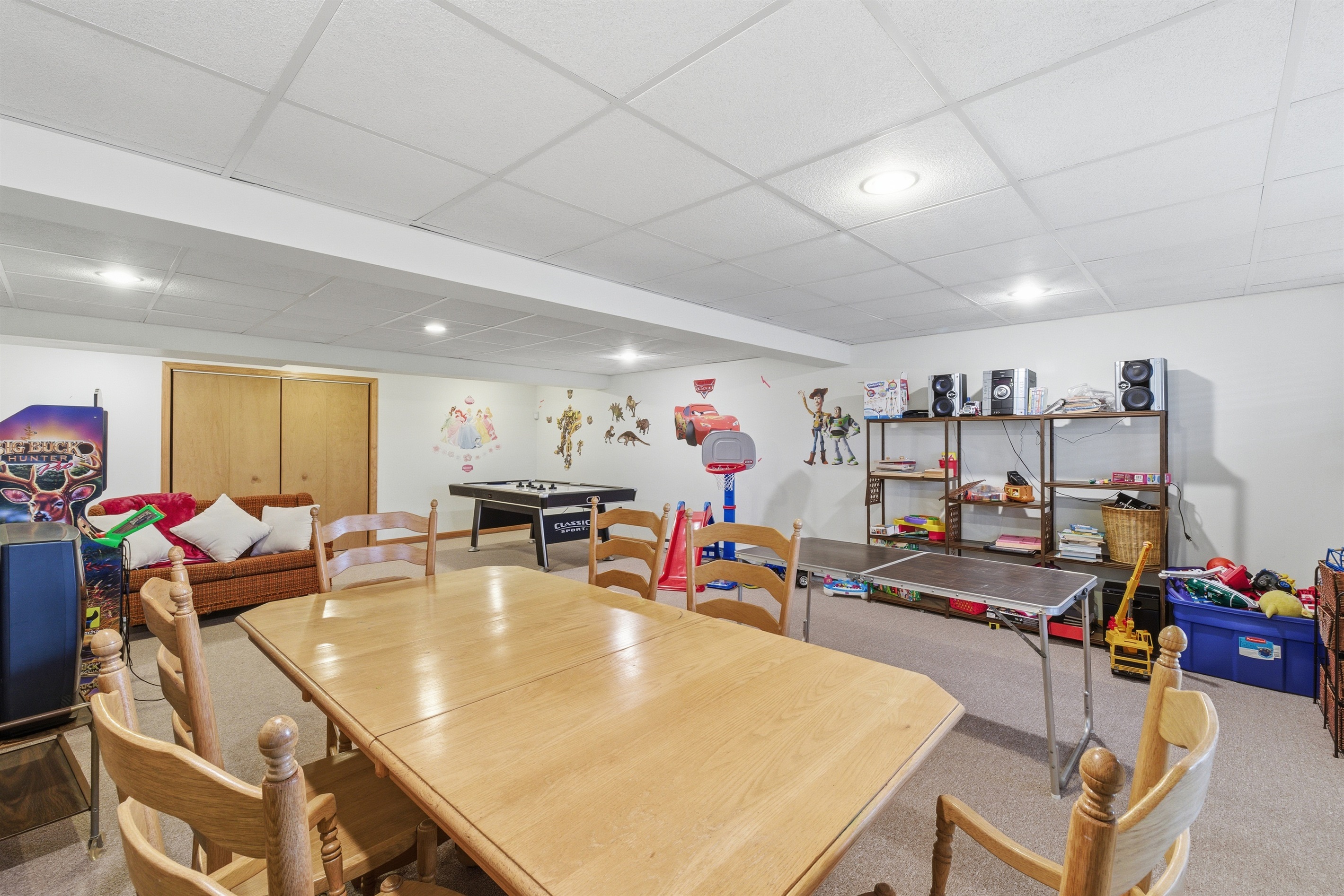 Playroom for kids and adults.  Air hockey, stereo system, toys, arcade, seating area.