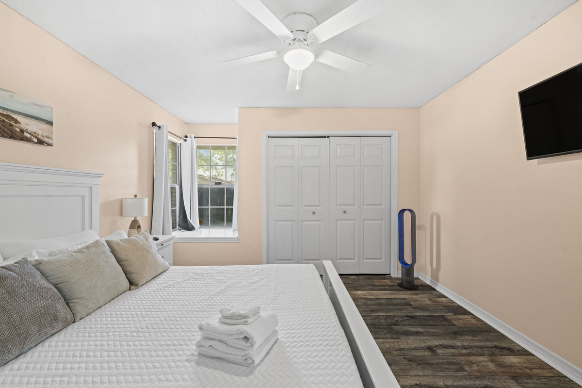 Cozy and light-filled, this bedroom offers a comfortable king bed and a wall-mounted TV for relaxing evenings.