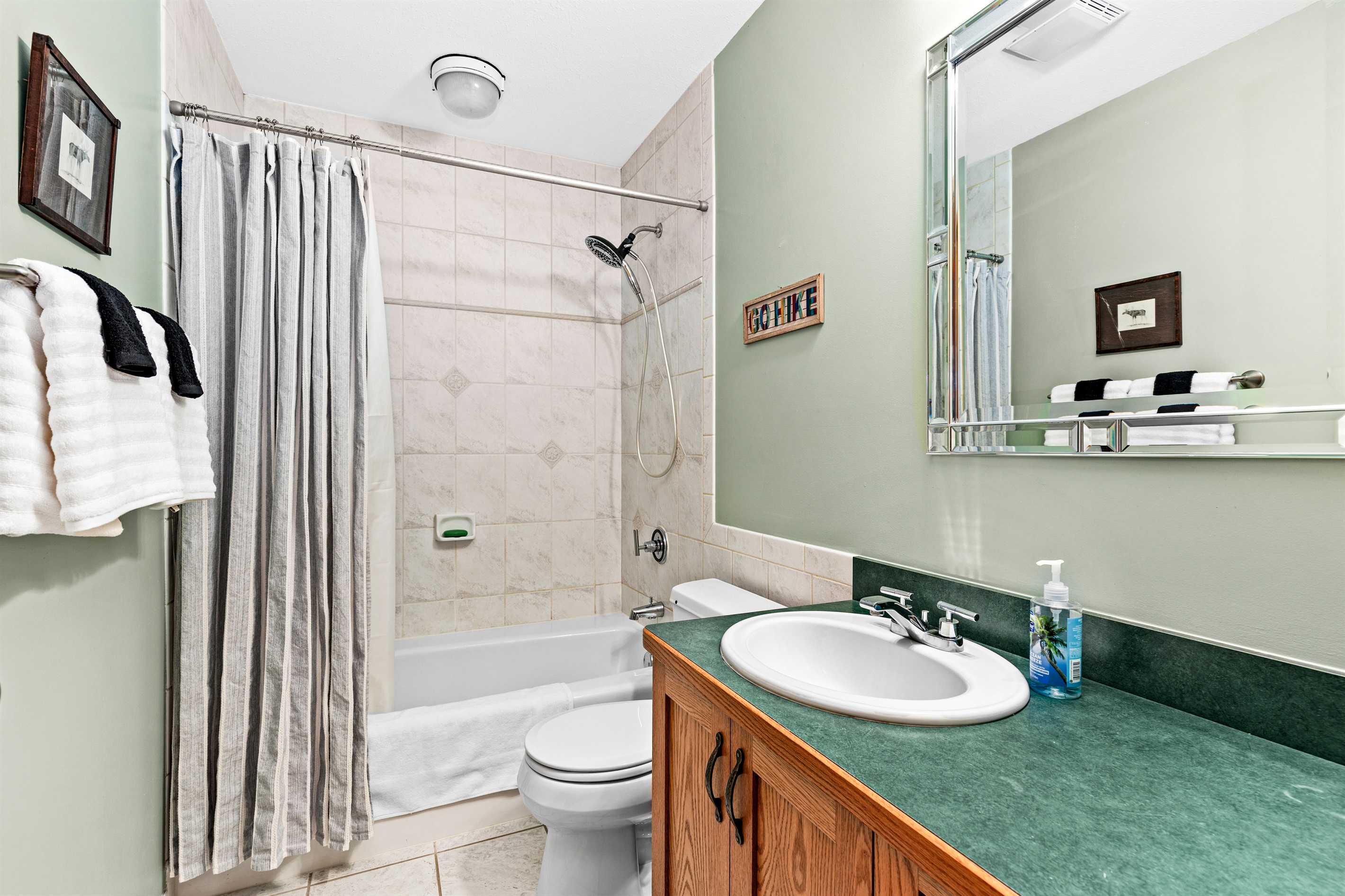 Convenient basement bathroom located just off the living room, featuring a shower-tub combo. A functional and comfortable space for guests to freshen up after a day of exploring.