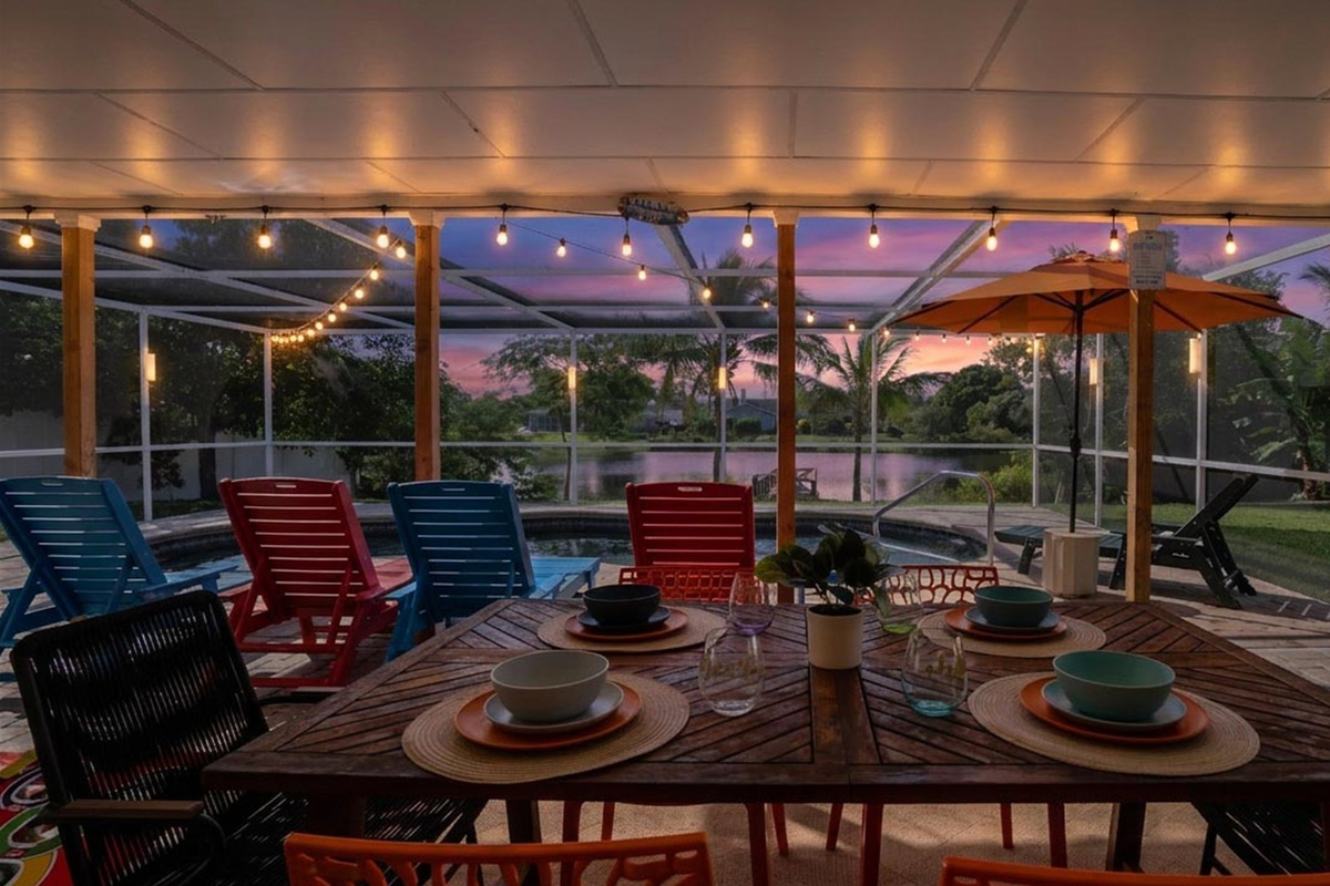 Outdoor dining table is ready for memorable meals beneath the lanai’s warm string lights.