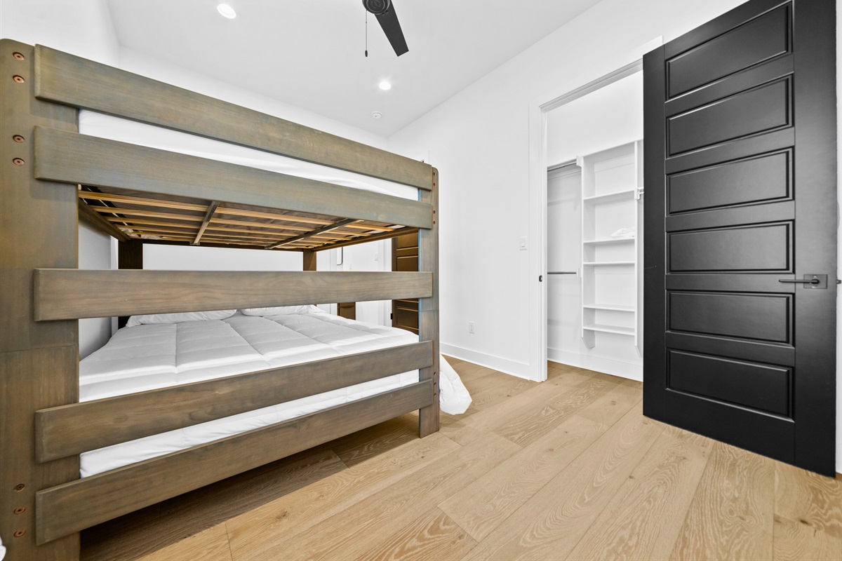 This queen bunk room combines playful charm with a sleek design, offering a practical and welcoming space for families or groups.