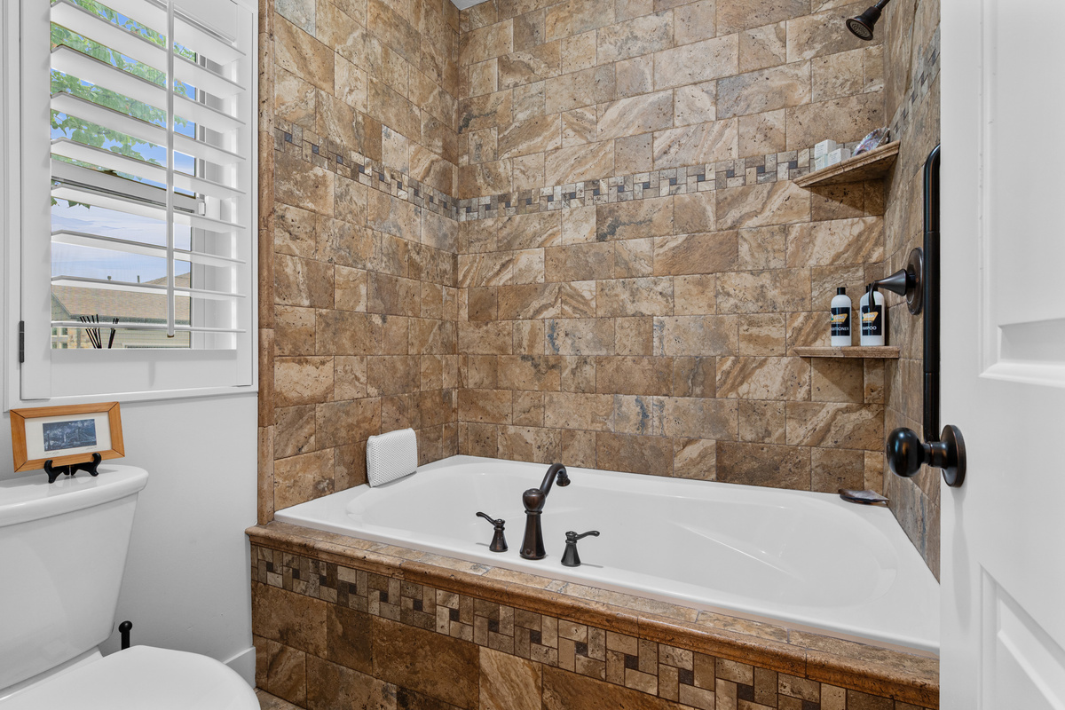 Relaxing soaking tub and stone shower combination perfect for unwinding after skiing or hiking adventures.