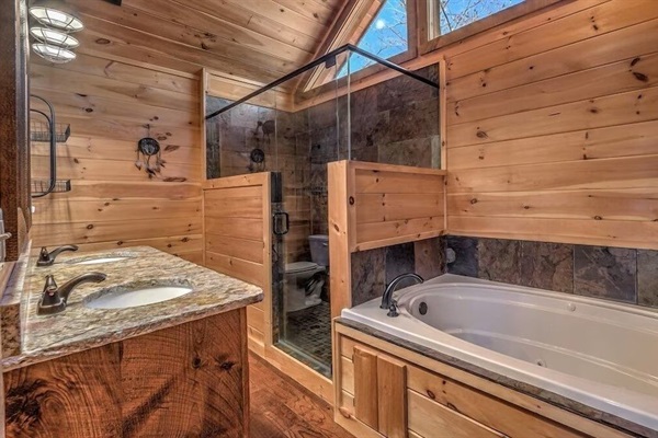 Spa-style bathroom with soaking tub, walk-in shower, and warm wood finishes for a relaxing mountain escape.