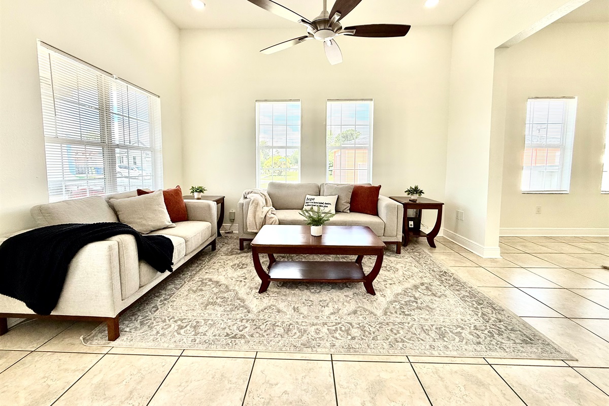 Vaulted ceilings and abundant windows elevate the space, while modern furniture adds function and flair.