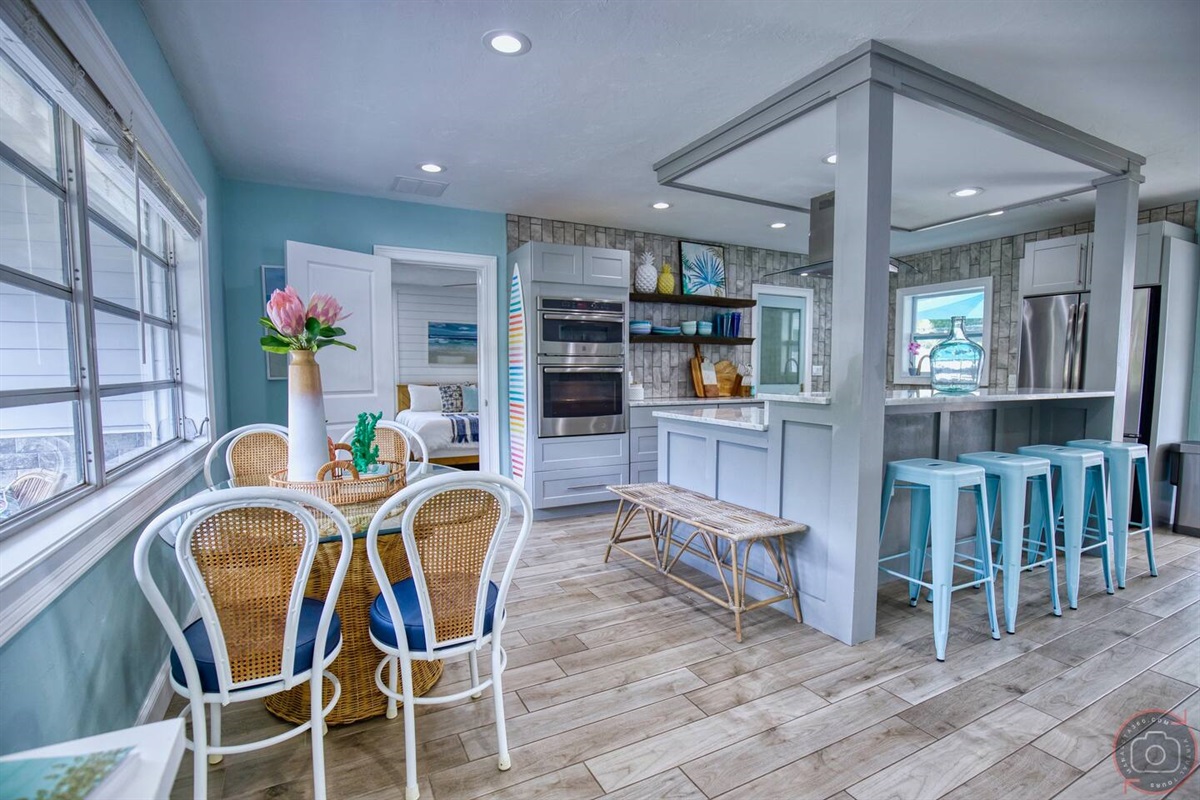 This stylish glass top table will accommodate four people while the bar to the right provides additional seating.