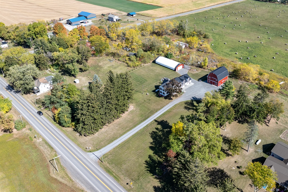 Wide aerial showing spacious layout, barns, and endless countryside views — a Finger Lakes gem