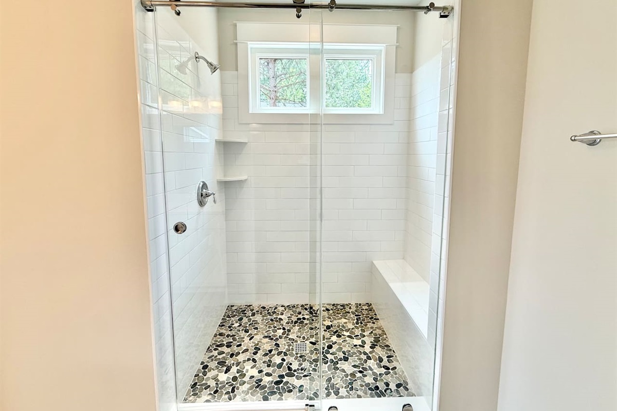 Guests will love the large shower with sliding glass barn style doors, pebble floors and the natural light that comes in from the windows!